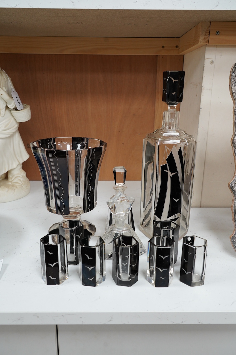 In the manner of Karl Palda (Czechoslovakian), an Art Deco flashed glass liqueur set comprising of a decanter and seven glasses, decorated with gulls and ships, together with a similar vase and two scent bottles and stop